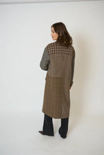 Load image into Gallery viewer, Woman wearing a long brown patchwork coat, jeans and boots against a white background.
