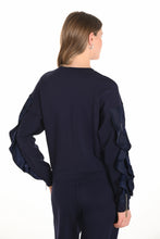 Load image into Gallery viewer, Woman wearing a navy blue ruffled sleeve top and navy blue pants against a white background.
