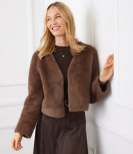 Load image into Gallery viewer, Woman wearing a brown fur coat and brown dress against a white wall.
