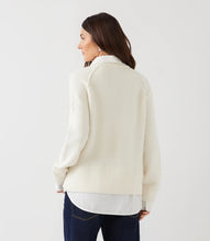 Load image into Gallery viewer, A woman shown from the back wearing a cream-colored layered knit sweater and dark blue jeans, against a plain white studio background.
