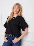 Load image into Gallery viewer, Woman wearing a black top and blue jeans against a white background.
