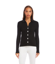 Load image into Gallery viewer, Woman wearing a black ribbed long sleeve top with buttons and white pants against a neutral background.
