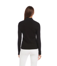 Load image into Gallery viewer, Woman wearing a black ribbed long sleeve top with buttons and white pants against a neutral background.
