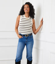 Load image into Gallery viewer, Woman wearing a brown and cream striped sleeveless top, blue jeans with belt and tall boots against a white wall. 
