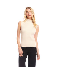 Load image into Gallery viewer, Woman wearing a beige sleeveless turtleneck sweater and black pants against a white background.
