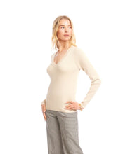 Load image into Gallery viewer, Woman wearing a beige sweater and plaid pants against a white background.

