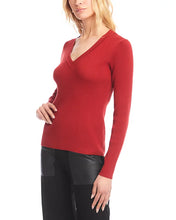Load image into Gallery viewer, Woman wearing a V-neck sweater in tomato with black pants against a white background.
