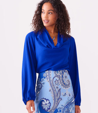 This stunning top in a striking blue color, exudes modern elegance with its luxurious moss crepe fabric that drapes gracefully and flatters the figure. With a sophisticated cowl neck, this top is suitable for both formal and casual occasions. Color- Royal blue. Cowl neck. Blouson sleeves. Elasticized cuffs. Fabric - Moss Crepe: 100% Polyester.