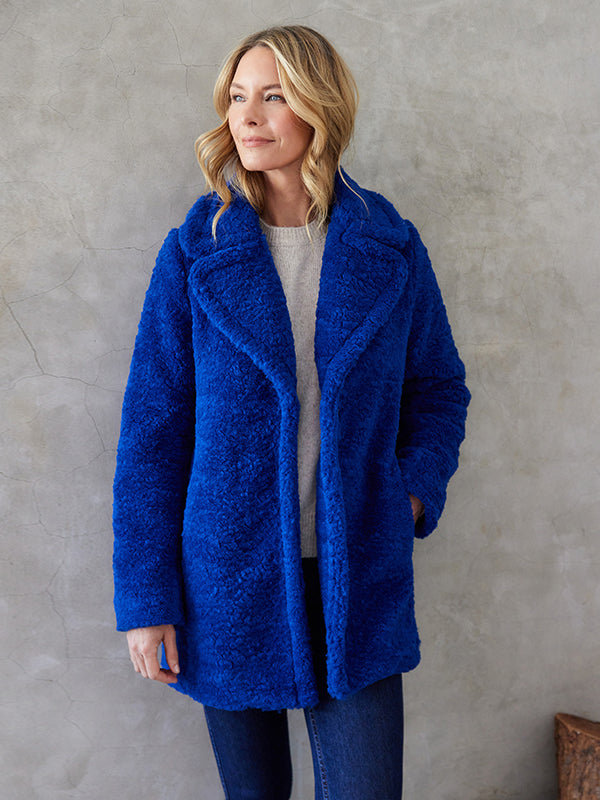 Experience ultimate warmth and comfort with the Rylan Royal Blue Sherpa Coat by Karen Kane. Featuring a cloverleaf lapel collar and front snaps, this coat is the perfect combination of style and cozy warmth to keep you snug during the coldest temperatures.  Color- Royal blue. Length: 31 7/8 inches (size M) Peaked lapel collar. Long sleeves. Lined.