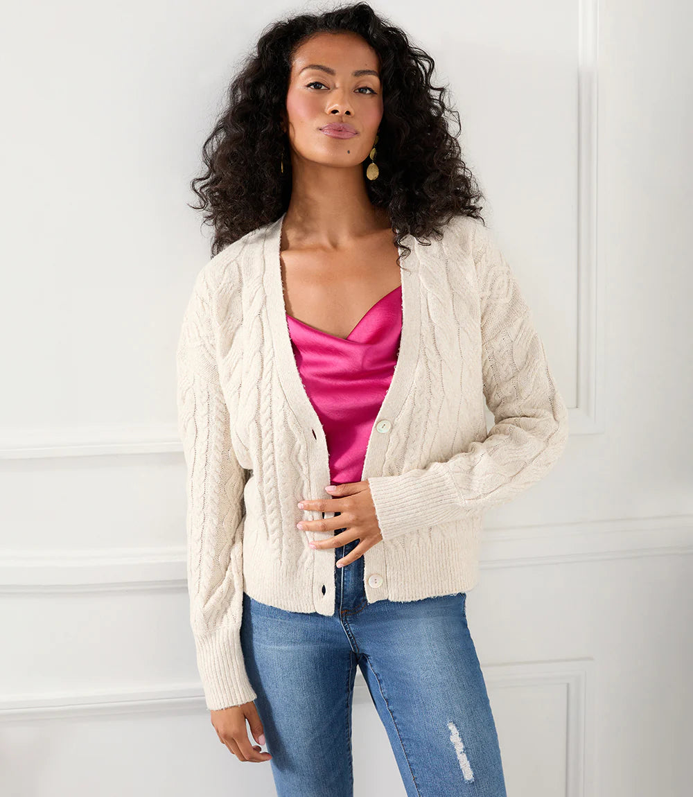 This cardigan sweater features intricate, textured yarns that form a sophisticated cable knit pattern. An ageless piece, it can be dressed up or worn casually for any occasion. Color- Sand. Long sleeve. Button down. Cable knit.