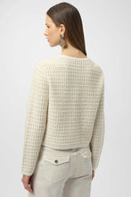 Load image into Gallery viewer, Woman wearing a winter white and gold sequined textured cardigan with gold buttons, winter white pants with gold buttons and gold statement earrings against a white background.
