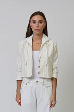 Load image into Gallery viewer, Woman wearing a white pinstripe jacket over a white tank and white pants against a plain background.
