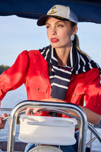 Load image into Gallery viewer, Woman on a boat wearing a red short sleeve top, striped scarf, and cap with an anchor emblem.
