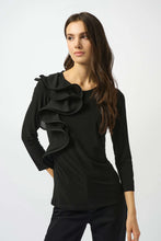Load image into Gallery viewer, Woman wearing a black ruffled top and black pants against a white background.
