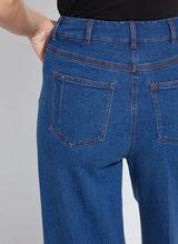 Load image into Gallery viewer, Close-up of a person wearing blue wide leg trouser jean.  Focus is on the back pockets.
