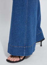 Load image into Gallery viewer, Close-up of a person wearing blue wide leg trouser jean and black sandals.  Focus is on the bottom hems.

