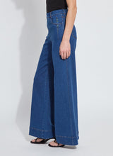 Load image into Gallery viewer, Person wearing blue wide-leg trouser jeans, black tee and black sandals against a white background.
