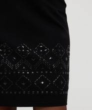 Load image into Gallery viewer, The EsQualo Senia Skirt in black features a beautifully detailed beaded hemline and a convenient zipper closure on the back, making it a necessary addition to any wardrobe. Its timeless design exudes sophistication and can be paired effortlessly with our matching Beate Blazer with Sleeve Embellishments - EsQualo W2405719 or elegant blouse for a polished look.
