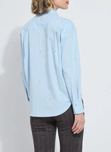 Load image into Gallery viewer, Woman wearing a light blue shirt with embellishments and dark plaid pants against a white background.
