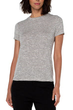 Load image into Gallery viewer, Woman wearing a tan and black stripe short sleeve top and black pants against a white background.
