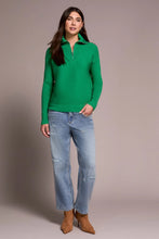 Load image into Gallery viewer, Woman wearing a green sweater, blue jeans and brown boots against a plain background.
