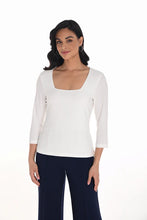Load image into Gallery viewer, Woman wearing an ivory three quarter-sleeve top and navy pants against a white background.
