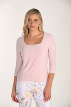 Load image into Gallery viewer, Woman wearing a light pink three quarter sleeve top and floral pants on a white background.
