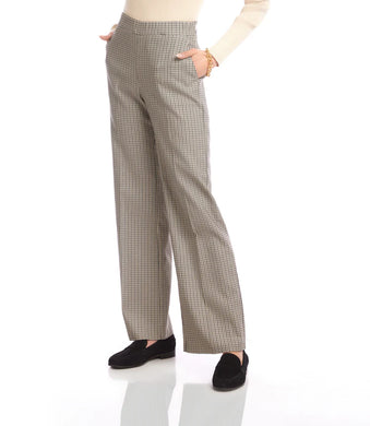 Model wearing black and cream checkered pants, cream top and black loafers against a white background.