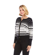 Load image into Gallery viewer, Woman wearing a black and off-white striped cardigan sweater and black pants against a white background.
