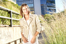 Load image into Gallery viewer, Introduce a touch of glamour with this stunning metallic gold vegan leather moto jacket adorned with golden buttons and zippers. A timeless and versatile addition to your wardrobe, this statement piece is built to withstand the test of time. Color - Sun clouds; gold metallic. Vegan leather with metallic finish. Gold hardware. Hook and eye closure. Zipper trim.

