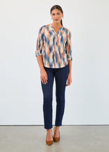 Load image into Gallery viewer, Woman wearing a patterned blouse, blue jeans and brown heels against a white background.
