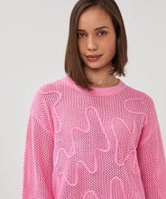 Load image into Gallery viewer, Close-up of woman wearing an open knit pink sweater with design  on a plain background.
