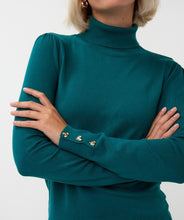 Load image into Gallery viewer, Close-up of the front of a teal turtleneck sweater with gold heart cufflinks against a white background.
