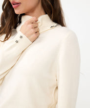 Load image into Gallery viewer, Elevate your wardrobe with the EsQualo Embellished Gem Collar Sweater. This stunning piece features a split turtleneck adorned with gem embellishments on both sides of the split collar, adding a touch of elegance and sophistication to your look. The sweater is designed with long sleeves, two floral gems on each cuff and a comfortable fit, making it perfect for both casual and dressy occasions.
