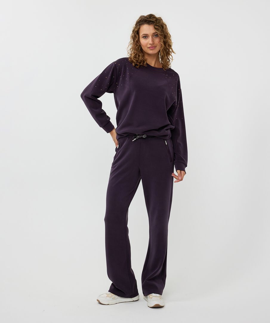 The EsQualo W2405714 Trine Trousers boast a luxurious satin finish and soft, breathable modal fabrication. The dark purple hue adds a touch of elegance, making them versatile for both casual and dressy occasions. With convenient satin pockets, zipper pockets, and a shimmering lurex drawstring, these trousers are both functional and stylish.