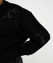 Load image into Gallery viewer, Close-up of black sequin embellishments on a black sweater against a white background.
