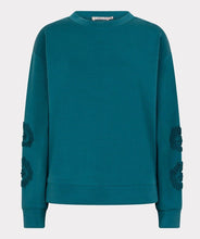 Load image into Gallery viewer, Teal modal sweater with floral embellishments on sleeves against a white background.

