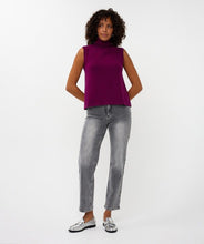 Load image into Gallery viewer, Woman wearing a purple sleeveless turtleneck sweater top, grey jeans and silver shoes against a white background.
