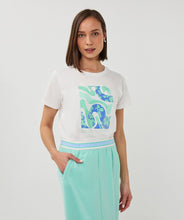 Load image into Gallery viewer, Woman wearing a white t-shirt with a colorful light mint and blue graphic and mint skirt on a white background.
