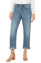 Load image into Gallery viewer, Model wearing white long top, light blue cuffed jeans and beige heels against a white background.
