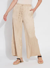 Load image into Gallery viewer, Designed with the modern traveler in mind, the Packable Pleated Palazzo Pant by Lysse blends effortless elegance with functional versatility. Made from silky Soft Touch Satin, these wide-leg trousers feature permanent pleats, an adjustable drawstring waist, and functional side pockets for a flattering yet practical silhouette. The raw-cut hem allows for easy alterations, while the 28-inch inseam makes them ideal for showcasing your favorite sandals or heels.
