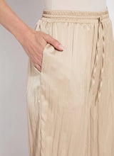 Load image into Gallery viewer, Designed with the modern traveler in mind, the Packable Pleated Palazzo Pant by Lysse blends effortless elegance with functional versatility. Made from silky Soft Touch Satin, these wide-leg trousers feature permanent pleats, an adjustable drawstring waist, and functional side pockets for a flattering yet practical silhouette. The raw-cut hem allows for easy alterations, while the 28-inch inseam makes them ideal for showcasing your favorite sandals or heels.
