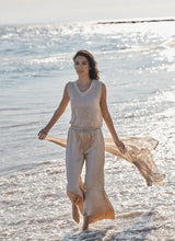Load image into Gallery viewer, Designed with the modern traveler in mind, the Packable Pleated Palazzo Pant by Lysse blends effortless elegance with functional versatility. Made from silky Soft Touch Satin, these wide-leg trousers feature permanent pleats, an adjustable drawstring waist, and functional side pockets for a flattering yet practical silhouette. The raw-cut hem allows for easy alterations, while the 28-inch inseam makes them ideal for showcasing your favorite sandals or heels.
