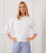 Load image into Gallery viewer, Woman wearing a white sweater and blue striped pants against a white background.
