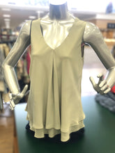 Load image into Gallery viewer, Mannequin wearing a light-colored green sleeveless top against a blurred store background.
