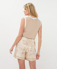 Load image into Gallery viewer, Woman wearing a sand-colored sleeveless top with off white contrast and safari print shorts against a white background.
