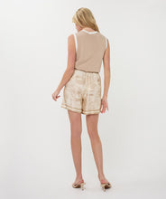 Load image into Gallery viewer, Woman wearing a sand-colored sleeveless top with off white contrast and safari print shorts against a white background.
