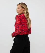 Load image into Gallery viewer, Who says winter has to be drab? Enhance your winter wardrobe with a touch of color. This stunning top features a vibrant multi color design that pairs well with denim or black pants. Wear it solo or layer it under a black blazer for a sophisticated look.
