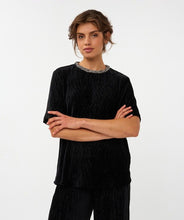 Load image into Gallery viewer, Woman wearing a black velvet short sleeve top with embellished neckline and black velvet pants against a white background.
