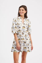 Load image into Gallery viewer, A woman modeling a white short-sleeve collared dress with a yellow and black illustrated pattern, photographed against a plain light gray studio background.
